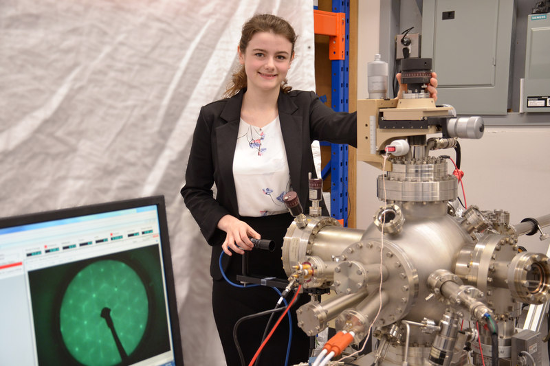 A University of Waterloo Honours Physics Student, Minoring in Astrophysics, with an OCI Vacuum Microengineering UHV System, a green LEED pattern visible on the system's monitor.